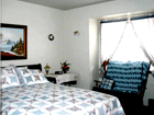 Serene and beautiful bedroom with loveseat.